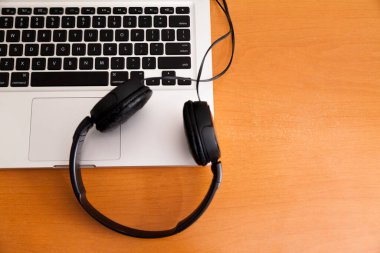 Kulaklıklı bir defter masanın üstünde. Podcast. Akıyor. Not defteri konsepti. Kulaklık konsepti.