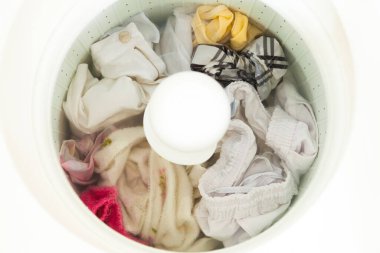 Çamaşır makinası kirli çamaşırları temizlemek için kullanılıyor ve muhtemelen kovid-19 ile kirletilmiş. Bakterileri önlemek için karantina sırasında. Temizlik konsepti Kıyafet konsepti.