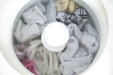 Çamaşır makinası kirli çamaşırları temizlemek için kullanılıyor ve muhtemelen kovid-19 ile kirletilmiş. Bakterileri önlemek için karantina sırasında. Temizlik konsepti Kıyafet konsepti.