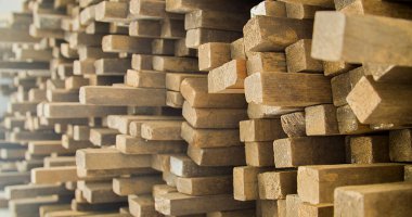 Ahşap tahtalar istiflenmiş ve marangozluk çerçevesinde düzenlenmiş. Sert ve kırsal ahşap, dokusu ve arka plan olarak güneş yüzüne vuruyor. Arka plan konsepti. Ahşap kavramı.