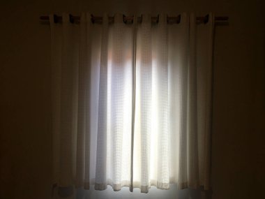 Aydınlatmaya gelen güneş ışığıyla dolu oda perdesi