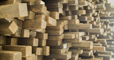 Ahşap tahtalar istiflenmiş ve marangozluk çerçevesinde düzenlenmiş. Sert ve kırsal ahşap, dokusu ve arka plan olarak güneş yüzüne vuruyor. Arka plan konsepti. Ahşap kavramı.