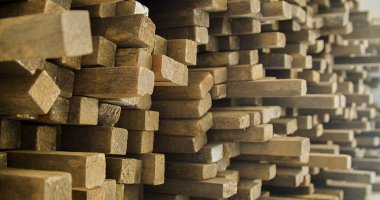 Ahşap tahtalar istiflenmiş ve marangozluk çerçevesinde düzenlenmiş. Sert ve kırsal ahşap, dokusu ve arka plan olarak güneş yüzüne vuruyor. Arka plan konsepti. Ahşap kavramı.