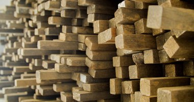 Ahşap tahtalar istiflenmiş ve marangozluk çerçevesinde düzenlenmiş. Sert ve kırsal ahşap, dokusu ve arka plan olarak güneş yüzüne vuruyor. Arka plan konsepti. Ahşap kavramı.