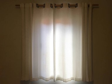 Aydınlatmaya gelen güneş ışığıyla dolu oda perdesi