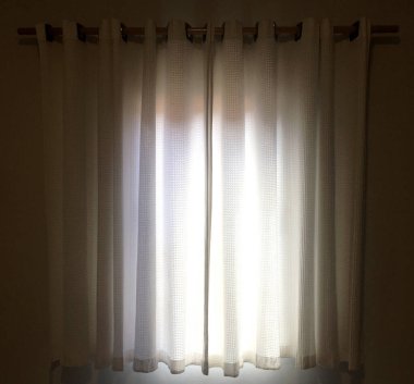 Aydınlatmaya gelen güneş ışığıyla dolu oda perdesi