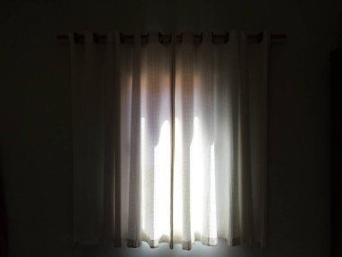 Aydınlatmaya gelen güneş ışığıyla dolu oda perdesi