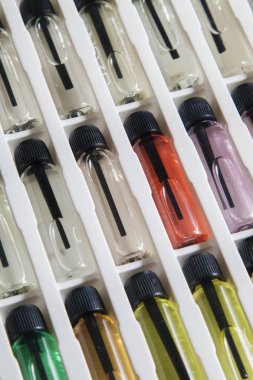 Masadaki makyaj çantasındaki farklı koku ve aromalı renkli parfüm şişeleri. Güzellik konsepti. Kadınsı bir kavram. Renkli konsept.