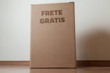 Tarafsız bir arkaplanı olan boş bir odada, yere bırakılan kutuda yazılı siparişin olduğu karton kutu. Teslimat. Ekonomi kavramı. İş konsepti. alışveriş kavramı. 