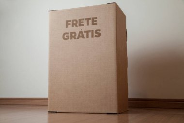 Tarafsız bir arkaplanı olan boş bir odada, yere bırakılan kutuda yazılı siparişin olduğu karton kutu. Teslimat. Ekonomi kavramı. İş konsepti. alışveriş kavramı. 