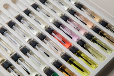 Masadaki makyaj çantasındaki farklı koku ve aromalı renkli parfüm şişeleri. Güzellik konsepti. Kadınsı bir kavram. Renkli konsept.