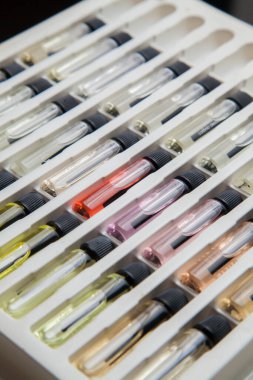 Masadaki makyaj çantasındaki farklı koku ve aromalı renkli parfüm şişeleri. Güzellik konsepti. Kadınsı bir kavram. Renkli konsept.