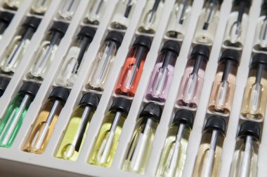 Masadaki makyaj çantasındaki farklı koku ve aromalı renkli parfüm şişeleri. Güzellik konsepti. Kadınsı bir kavram. Renkli konsept.