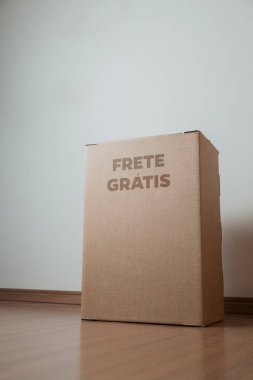 Tarafsız bir arkaplanı olan boş bir odada, yere bırakılan kutuda yazılı siparişin olduğu karton kutu. Teslimat. Ekonomi kavramı. İş konsepti. alışveriş kavramı. 