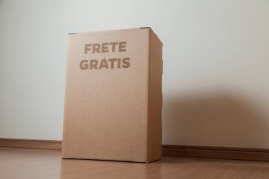 Tarafsız bir arkaplanı olan boş bir odada, yere bırakılan kutuda yazılı siparişin olduğu karton kutu. Teslimat. Ekonomi kavramı. İş konsepti. alışveriş kavramı. 