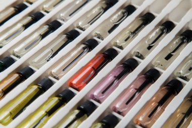 Masadaki makyaj çantasındaki farklı koku ve aromalı renkli parfüm şişeleri. Güzellik konsepti. Kadınsı bir kavram. Renkli konsept.