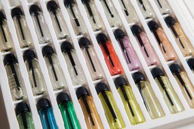 Masadaki makyaj çantasındaki farklı koku ve aromalı renkli parfüm şişeleri. Güzellik konsepti. Kadınsı bir kavram. Renkli konsept.