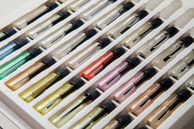 Masadaki makyaj çantasındaki farklı koku ve aromalı renkli parfüm şişeleri. Güzellik konsepti. Kadınsı bir kavram. Renkli konsept.