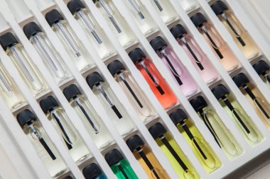 Masadaki makyaj çantasındaki farklı koku ve aromalı renkli parfüm şişeleri. Güzellik konsepti. Kadınsı bir kavram. Renkli konsept.