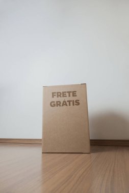 Tarafsız bir arkaplanı olan boş bir odada, yere bırakılan kutuda yazılı siparişin olduğu karton kutu. Teslimat. Ekonomi kavramı. İş konsepti. alışveriş kavramı. 