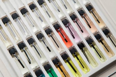 Masadaki makyaj çantasındaki farklı koku ve aromalı renkli parfüm şişeleri. Güzellik konsepti. Kadınsı bir kavram. Renkli konsept.