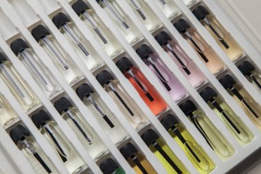 Masadaki makyaj çantasındaki farklı koku ve aromalı renkli parfüm şişeleri. Güzellik konsepti. Kadınsı bir kavram. Renkli konsept.