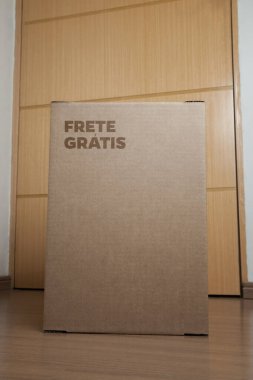 Tarafsız bir arkaplanı olan boş bir odada, yere bırakılan kutuda yazılı siparişin olduğu karton kutu. Teslimat. Ekonomi kavramı. İş konsepti. alışveriş kavramı. 