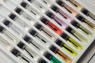 Masadaki makyaj çantasındaki farklı koku ve aromalı renkli parfüm şişeleri. Güzellik konsepti. Kadınsı bir kavram. Renkli konsept.