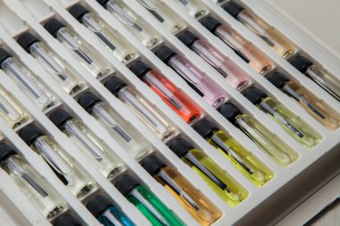 Masadaki makyaj çantasındaki farklı koku ve aromalı renkli parfüm şişeleri. Güzellik konsepti. Kadınsı bir kavram. Renkli konsept.