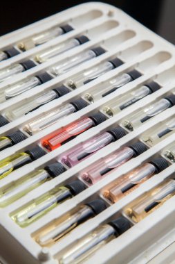 Masadaki makyaj çantasındaki farklı koku ve aromalı renkli parfüm şişeleri. Güzellik konsepti. Kadınsı bir kavram. Renkli konsept.