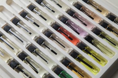 Masadaki makyaj çantasındaki farklı koku ve aromalı renkli parfüm şişeleri. Güzellik konsepti. Kadınsı bir kavram. Renkli konsept.