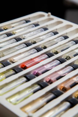 Masadaki makyaj çantasındaki farklı koku ve aromalı renkli parfüm şişeleri. Güzellik konsepti. Kadınsı bir kavram. Renkli konsept.