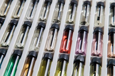 Masadaki makyaj çantasındaki farklı koku ve aromalı renkli parfüm şişeleri. Güzellik konsepti. Kadınsı bir kavram. Renkli konsept.