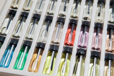 Masadaki makyaj çantasındaki farklı koku ve aromalı renkli parfüm şişeleri. Güzellik konsepti. Kadınsı bir kavram. Renkli konsept.