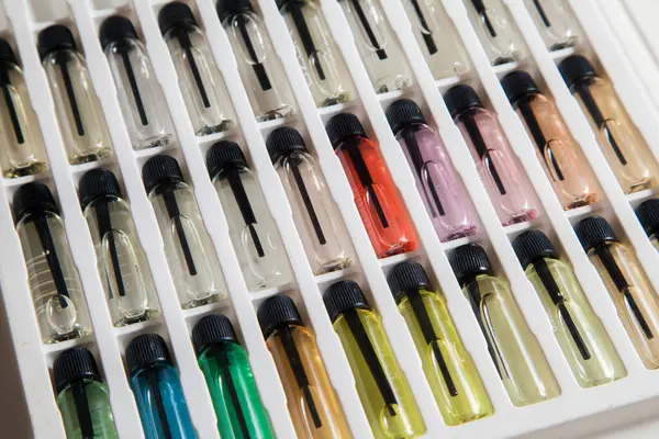 Masadaki makyaj çantasındaki farklı koku ve aromalı renkli parfüm şişeleri. Güzellik konsepti. Kadınsı bir kavram. Renkli konsept.