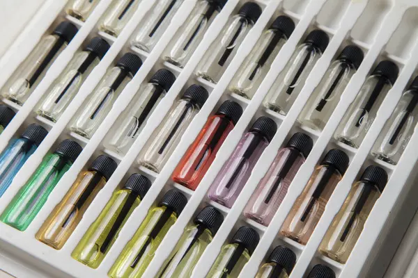 Masadaki makyaj çantasındaki farklı koku ve aromalı renkli parfüm şişeleri. Güzellik konsepti. Kadınsı bir kavram. Renkli konsept.