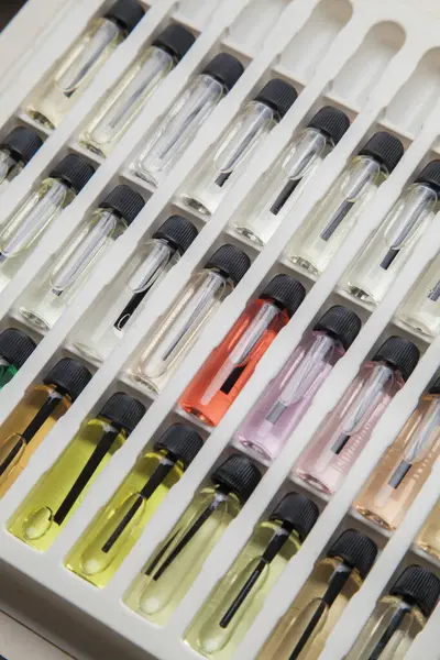 Masadaki makyaj çantasındaki farklı koku ve aromalı renkli parfüm şişeleri. Güzellik konsepti. Kadınsı bir kavram. Renkli konsept.