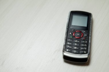 Eski hücresel cihaz merkez ofisteki masanın üstüne yerleştirilmiş, ekranı, klavyeyi ve eski elektronik cihaz teknolojisini gösteriyor. Teknoloji konsepti. iletişim konsepti