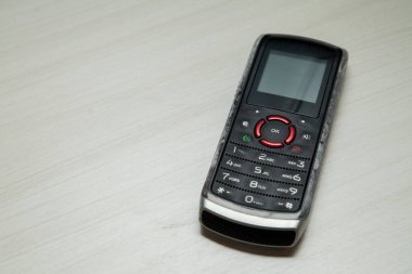 Eski hücresel cihaz merkez ofisteki masanın üstüne yerleştirilmiş, ekranı, klavyeyi ve eski elektronik cihaz teknolojisini gösteriyor. Teknoloji konsepti. iletişim konsepti