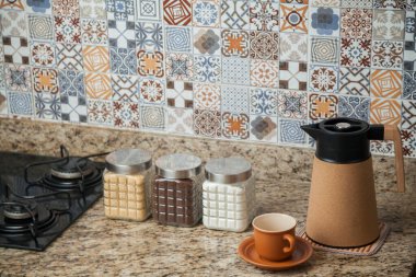 Kahve termoslu kahvaltı masası, bir fincan şeker, kahve ve sos. Arka planda fayanslarla süslenmiş tipik Brezilya mutfağı. Yemek konsepti. Kahvaltı konsepti. 