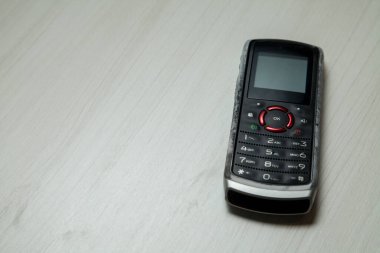 Eski hücresel cihaz merkez ofisteki masanın üstüne yerleştirilmiş, ekranı, klavyeyi ve eski elektronik cihaz teknolojisini gösteriyor. Teknoloji konsepti. iletişim konsepti