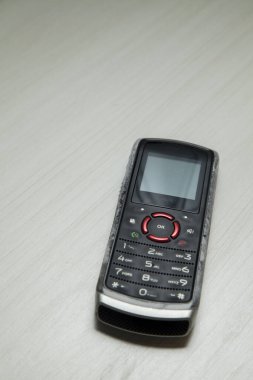 Eski hücresel cihaz merkez ofisteki masanın üstüne yerleştirilmiş, ekranı, klavyeyi ve eski elektronik cihaz teknolojisini gösteriyor. Teknoloji konsepti. iletişim konsepti