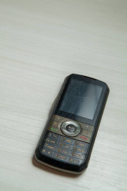 Eski hücresel cihaz merkez ofisteki masanın üstüne yerleştirilmiş, ekranı, klavyeyi ve eski elektronik cihaz teknolojisini gösteriyor. Teknoloji konsepti. iletişim konsepti