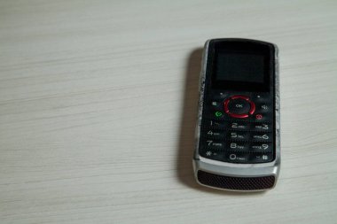 Eski hücresel cihaz merkez ofisteki masanın üstüne yerleştirilmiş, ekranı, klavyeyi ve eski elektronik cihaz teknolojisini gösteriyor. Teknoloji konsepti. iletişim konsepti