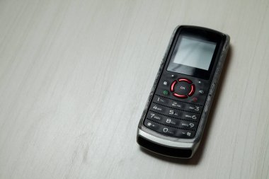 Eski hücresel cihaz merkez ofisteki masanın üstüne yerleştirilmiş, ekranı, klavyeyi ve eski elektronik cihaz teknolojisini gösteriyor. Teknoloji konsepti. iletişim konsepti