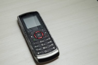 Eski hücresel cihaz merkez ofisteki masanın üstüne yerleştirilmiş, ekranı, klavyeyi ve eski elektronik cihaz teknolojisini gösteriyor. Teknoloji konsepti. iletişim konsepti