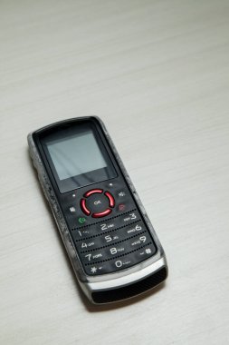 Eski hücresel cihaz merkez ofisteki masanın üstüne yerleştirilmiş, ekranı, klavyeyi ve eski elektronik cihaz teknolojisini gösteriyor. Teknoloji konsepti. iletişim konsepti