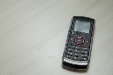 Eski hücresel cihaz merkez ofisteki masanın üstüne yerleştirilmiş, ekranı, klavyeyi ve eski elektronik cihaz teknolojisini gösteriyor. Teknoloji konsepti. iletişim konsepti