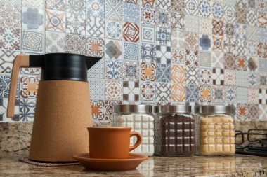 Kahve termoslu kahvaltı masası, bir fincan şeker, kahve ve sos. Arka planda fayanslarla süslenmiş tipik Brezilya mutfağı. Yemek konsepti. Kahvaltı konsepti. 