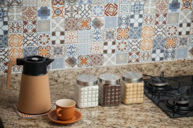 Kahve termoslu kahvaltı masası, bir fincan şeker, kahve ve sos. Arka planda fayanslarla süslenmiş tipik Brezilya mutfağı. Yemek konsepti. Kahvaltı konsepti. 